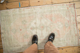 Person's perspective of a vintage Oushak rug, highlighting its scale and soft, worn pile.