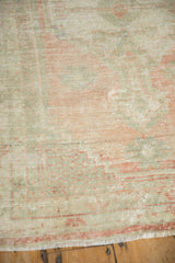 Distressed low pile of a vintage Turkish rug in soft rose and pale jade green.