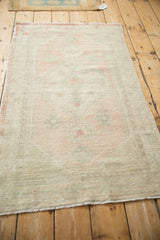 Angled view of the vintage Oushak rug, displaying its soft, even wear and low pile.