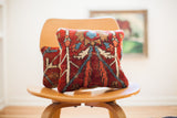 Vintage red Persian rug pillow with bold abstract geometric patterns in blue, beige, and rust tones.