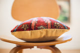 Red Persian rug pillow's textured vintage fragment and soft mustard velvet backing.