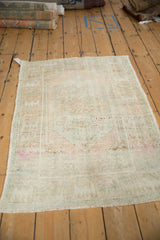 Distressed Turkish Oushak rug from an angle, showcasing the softly faded pile and pastel hues.