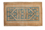 A vintage distressed Oushak rug with a dusty blue center medallion and scattered golden starbursts.