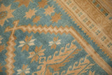 Evenly worn texture of a hand-knotted Oushak rug with gold starbursts on a dusty blue field.