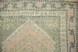 Vintage Distressed Oushak rug corner, pale pink flower, green vine, oxidized silver tones.