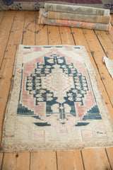 Distressed Oushak rug corner with stepped geometric motifs, abrashed pink, blue, worn pile.