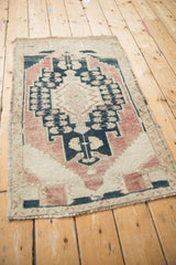 Distressed Oushak rug corner revealing muted geometric pattern and abrashed field.
