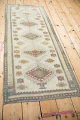 Ivory vintage distressed Oushak runner, central gul medallions, muted raspberry, gold, silver hues.