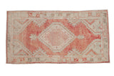 Distressed vintage Turkish Oushak rug with central medallion in dusty brick red, antique ivory, olive green.