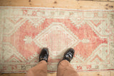 Distressed Oushak rug with abrash, pale brick red and antique ivory field patterns.