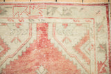 Distressed Oushak rug pile with even wear, featuring dusty pale brick red and antique ivory.