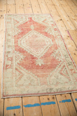 Distressed Oushak rug medallion: interlaced pattern in dusty brick red, antique ivory, pale olive green.