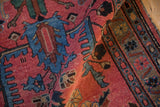 Folded section of the vintage Persian Mehreban runner, showing raspberry red pile and blue palmette motifs.