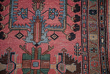 Mehreban runner close-up: pale raspberry field, blue tree of life motif, natural ground border.