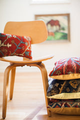 Small Persian Rug Pillow, a vintage fragment with ruby red and sapphire blue curvilinear patterns.