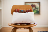 Smooth white suede backing of the Small Persian Rug Pillow with a peek of patterned fabric.