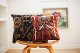 Late 19th century Turkish rug pillow, rich red with tribal geometric patterns, beside a dark woven pillow.