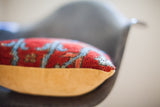 Side view of red Persian rug pillow, showing texture of vintage rug and mustard velvet.