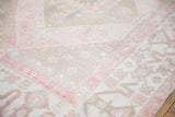 Softly worn, low pile texture of a vintage Oushak carpet in dusty blush, ivory, and beige.