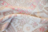 A gentle fold reveals the soft, distressed texture of a vintage Oushak carpet.