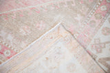 The hand-knotted foundation and machine-bound side of a vintage distressed Oushak carpet.