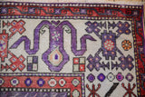 Hand-knotted Oushak rug with prominent violet geometric patterns and red cloudband border.