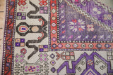 Distressed Oushak carpet corner with violet main field, patterned ivory sections, and geometric borders.
