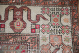 Serrated floral and stepped medallion details on a distressed Turkish Oushak rug in earthy tones.