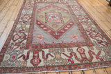 Low angle view of a distressed Turkish Oushak carpet showing its full length and geometric pattern.
