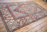 Angled perspective of a vintage distressed Oushak carpet's full geometric pattern.