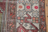 Close-up of geometric cloudband and serrated pinwheel floral motifs on a vintage Oushak rug.