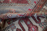 Distressed low-pile texture of a vintage Oushak rug with copper and sage green geometric patterns.