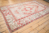 Distressed Oushak rug with faded red geometric cloudband border, ivory field.