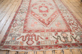 Distressed Vintage Oushak carpet with geometric cloudband border and fringed end.
