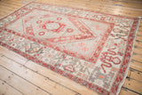 Distressed Oushak rug corner with geometric cloudband border and ivory field details.