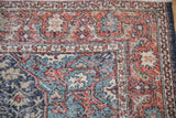 Distressed Sparta rug corner, terra cotta, navy, slate blue floral motifs, visible wear.