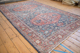 Distressed vintage Sparta rug, intricate floral blossoms, terra cotta, navy, and visible wear.