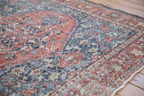 Distressed Sparta rug detail, showing mostly even wear on navy and terra cotta florals.