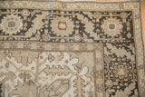 Distressed Turkish Heriz rug detail: antique ivory field, dark chocolate brown border, worn geometric patterns.
