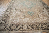 Distressed Turkish Heriz carpet showcasing geometric patterns, dusty teal accents, and floral border.