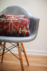 Vintage Persian rug pillow displaying red, blue, and beige intricate hand-knotted patterns.