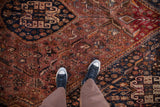 Vintage Qashqai carpet with feet, showcasing rust, navy, tangerine floral and animal motifs.