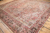 Distressed edge and secured fringe of the Mehrivan carpet, displaying faded red, brown, and blue patterns.