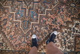 Close view of the Mehrivan carpet's stepped medallion and floral field in blush, blue, and brown.