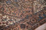 Detailed view of stepped medallions and palmettes in dusty blush, sapphire blue, and brown.