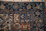 Vintage Mehrivan rug corner: dusty terra cotta turtle border and navy vine motifs.