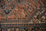 Navy turtle samovar border on a vintage Mehrivan rug with dusty terra cotta leaf field.