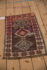 Geometric medallion with pink and plum tones, showing charming abrash and distressed pile.