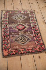Distressed Turkish Kars rug with geometric plum, pink, aubergine, and ivory patterns.