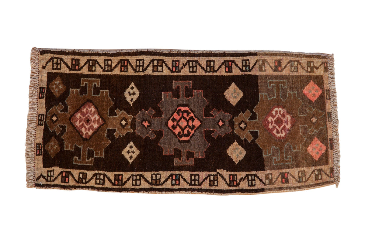 Vintage distressed Kars rug with three geometric medallions in dark brown, sand, and blush pink tones.